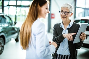 Car salesperson using automated inventory records as part of her strategy for how to improve car sales