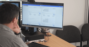 Car salesperson looking at SalesLogs dealership reporting on computer