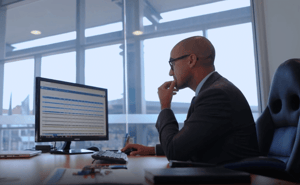 Dealership principal looking at financial reporting on computer